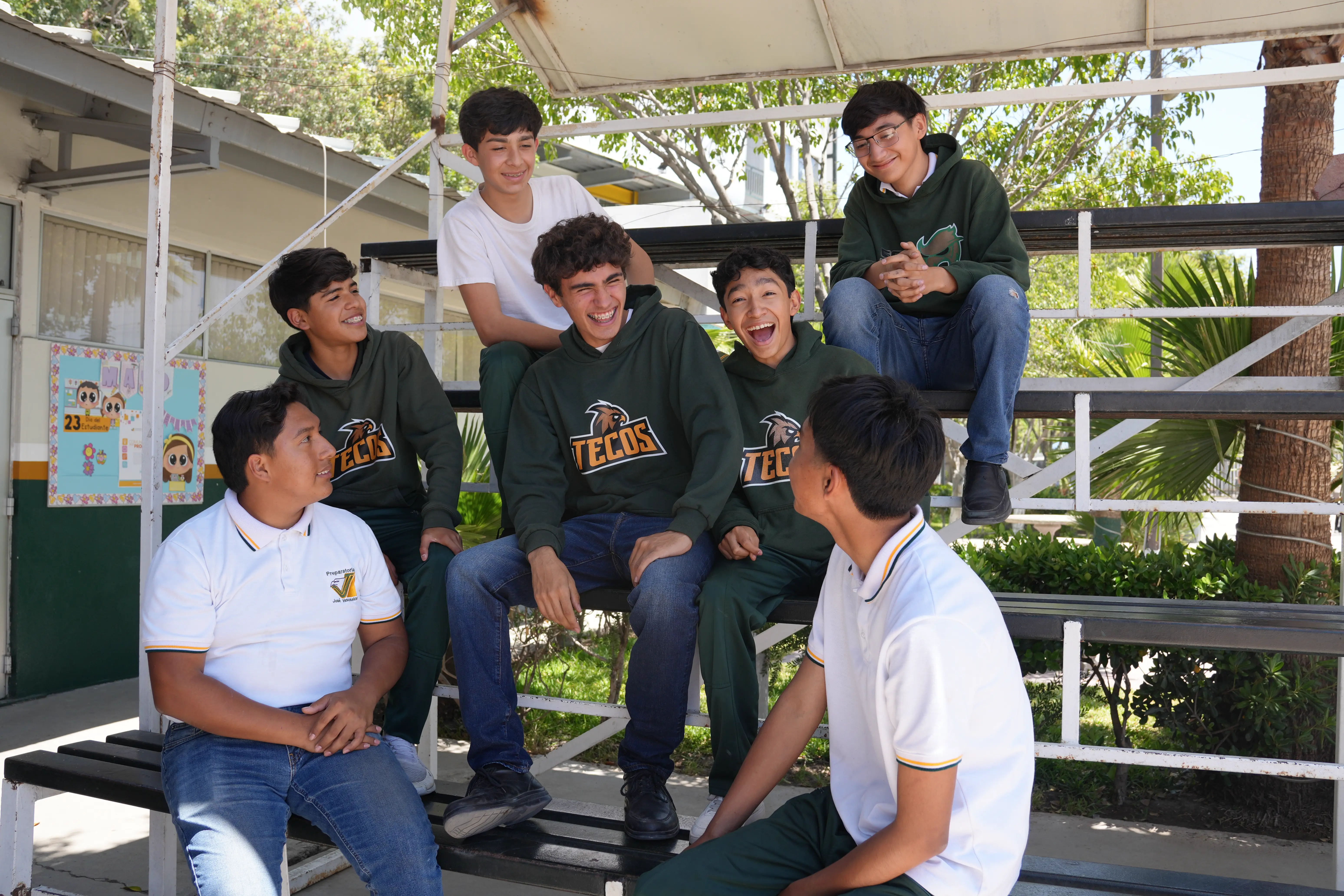 Estudiantes conviviendo en las gradas de la escuela