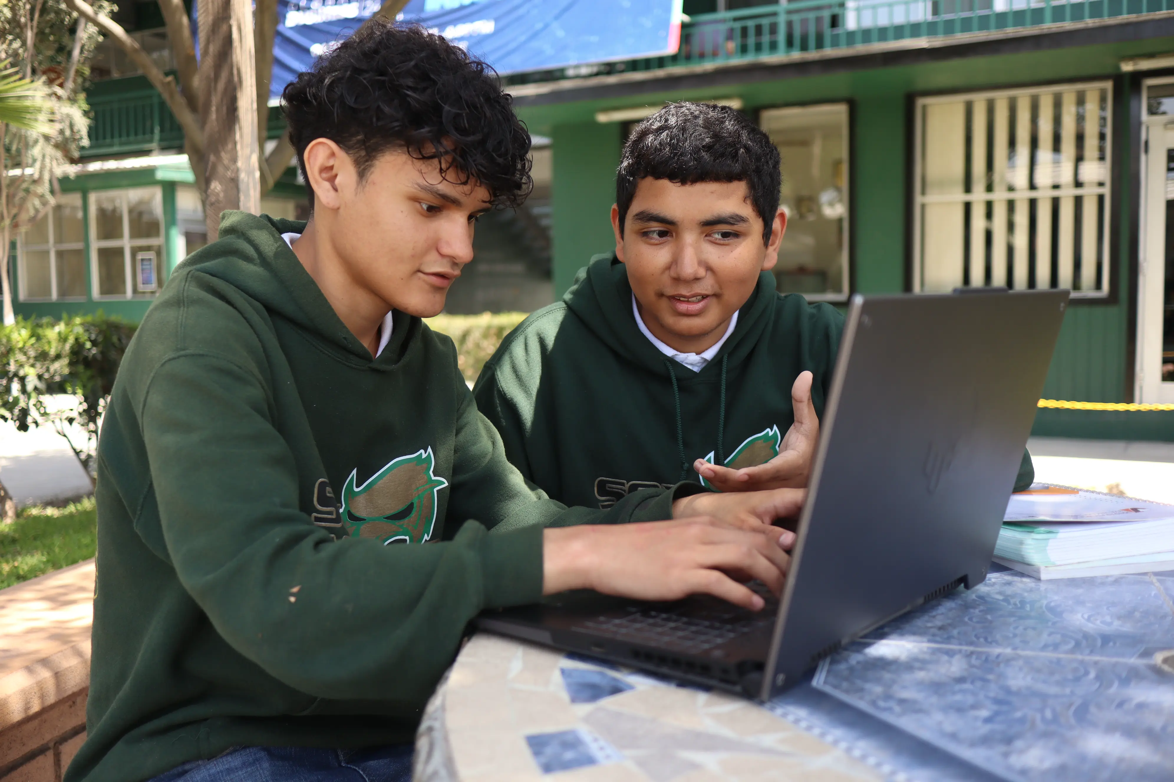 Alumnos usando una laptop en el campus